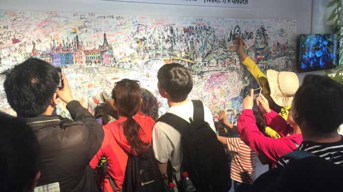 Un « coloriage géant » – 1 m 80 sur 15 mètres ! — vient animer le Pavillon France. Le paysagiste et sculpteur Claude Pasquer a conçu et dessiné une fresque ludique qui met en avant notre patrimoine de jardins. L’occasion d’échanges intergénérationnels et de symboliques sur la diversité humaine. © C. Julhiet-Détroyat/C. Pasquer